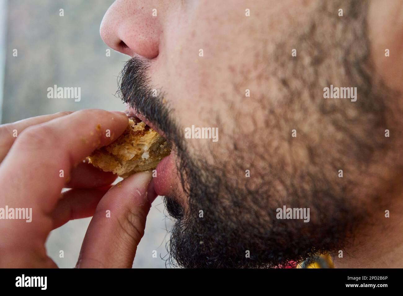 Mouth bites a piece of bread Stock Photo
