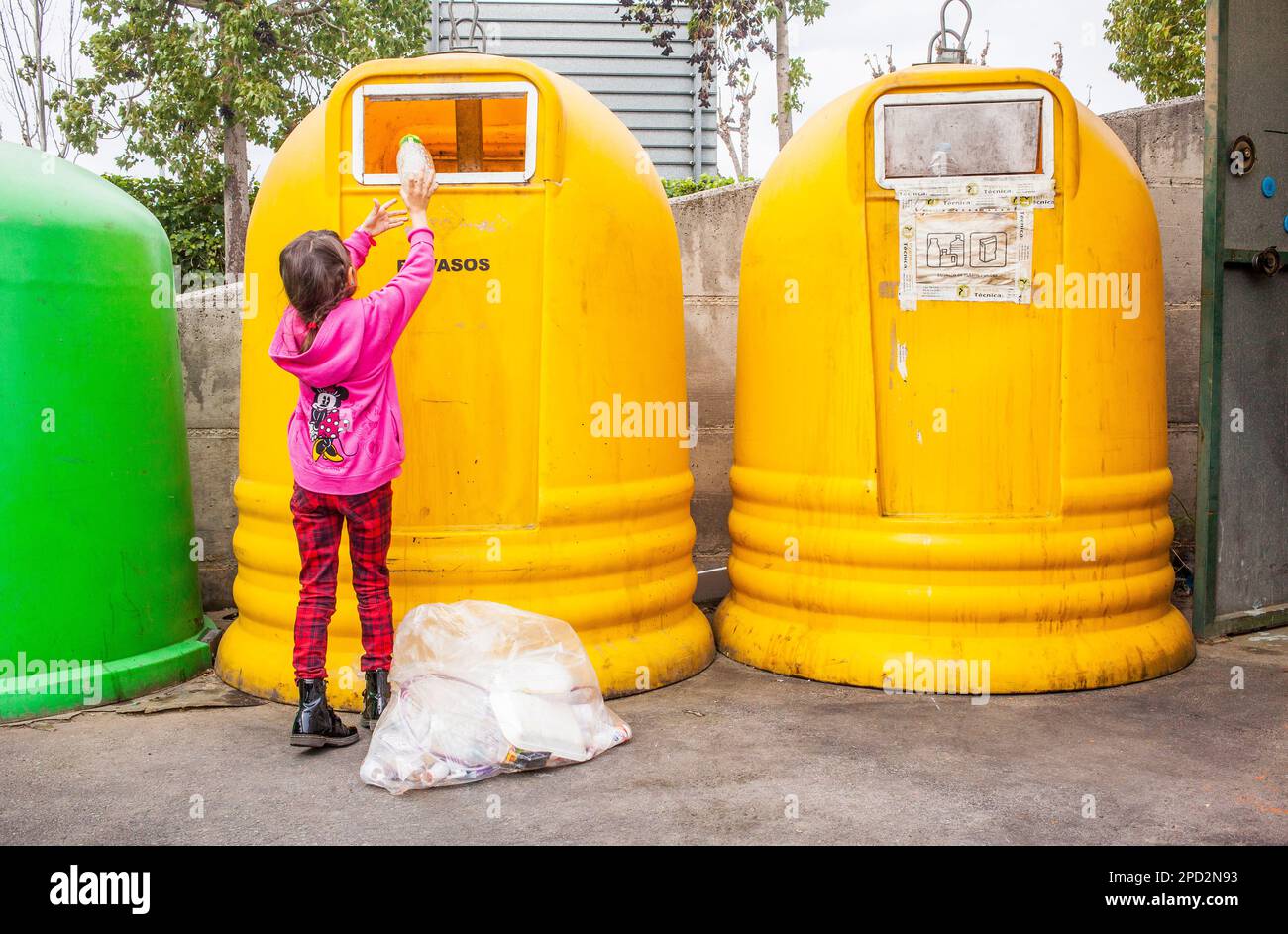 Containers of plastic for waste separation. Girl places plastic into a