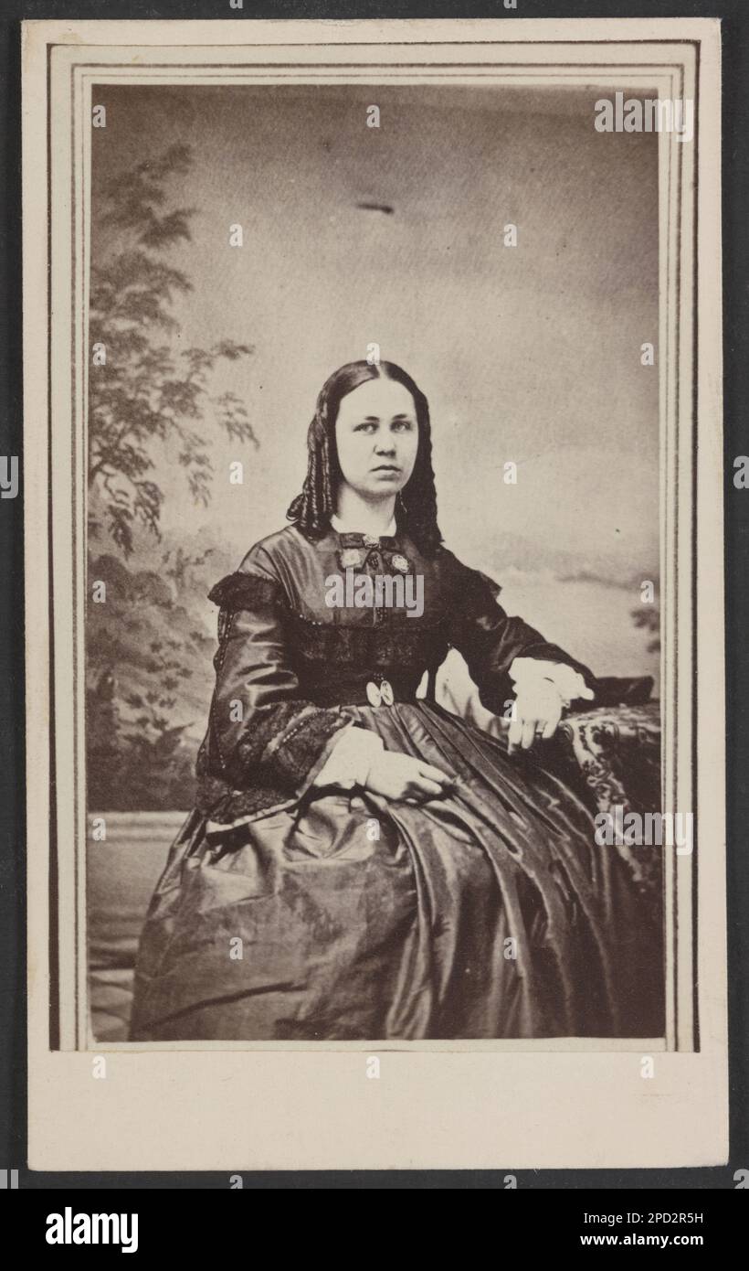 Unidentified woman in front of painted backdrop showing landscape. Title devised by Library staff, Date based on tax revenue stamp on verso. Women, 1860-1870, Backdrops, 1860-1870. Stock Photo