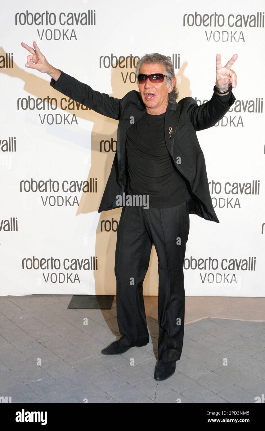 Fashion designer Roberto Cavalli gestures to photographers as he ...
