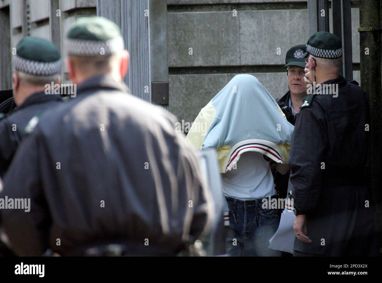 One of the five suspects charged with murder is led away by police from Ballymena court