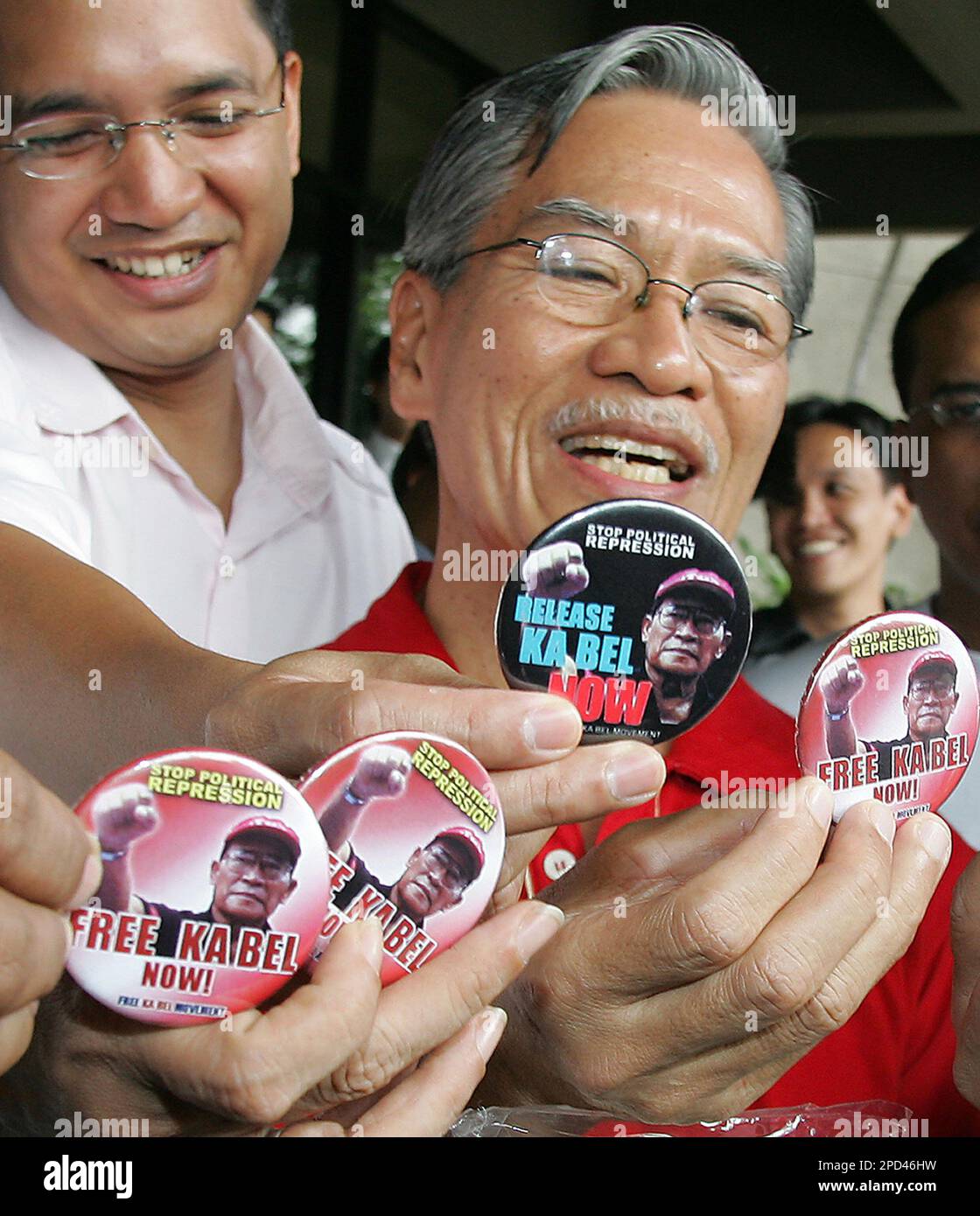 Left-wing Congressmen, Teddy Casino, left, and Satur Ocampo, show slogans before visiting the remaining leftwing leader Crispin Beltran who is still in police custody at a hospital in suburban Quezon city, north of Manila, Philippines, Tuesday, May 9, 2006. The five lawmakers who took a two-month refuge at Congress went out yesterday after a court dismissed charges of coup accusations against them. (AP Photo/Aaron Favila) Stock Photo