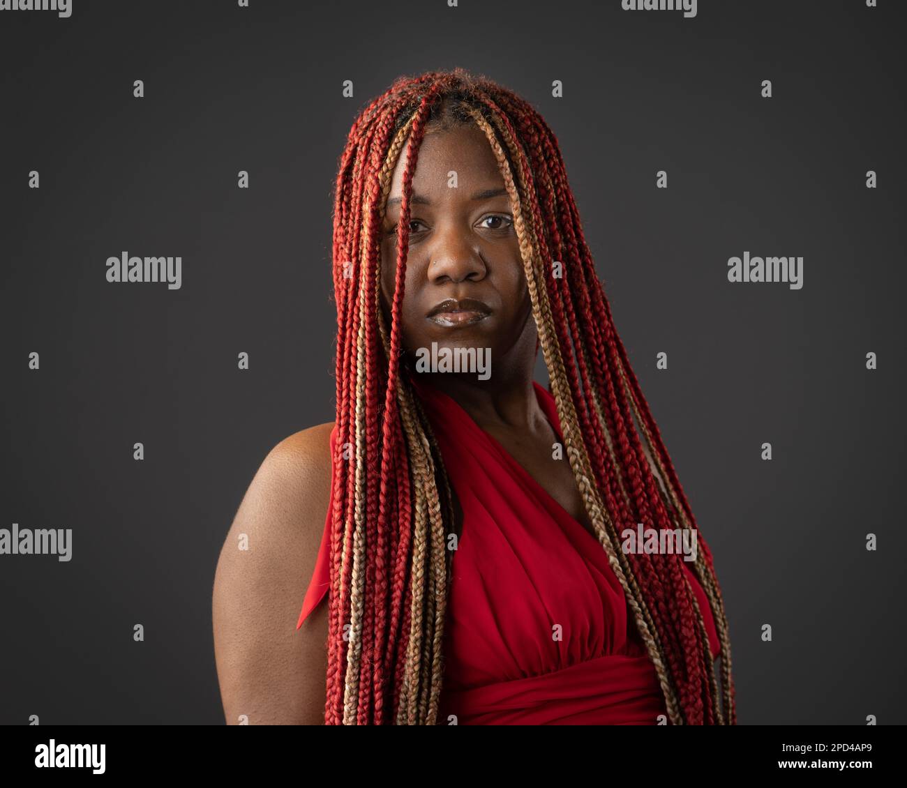 A portrait of a young African American female with red braids against a ...