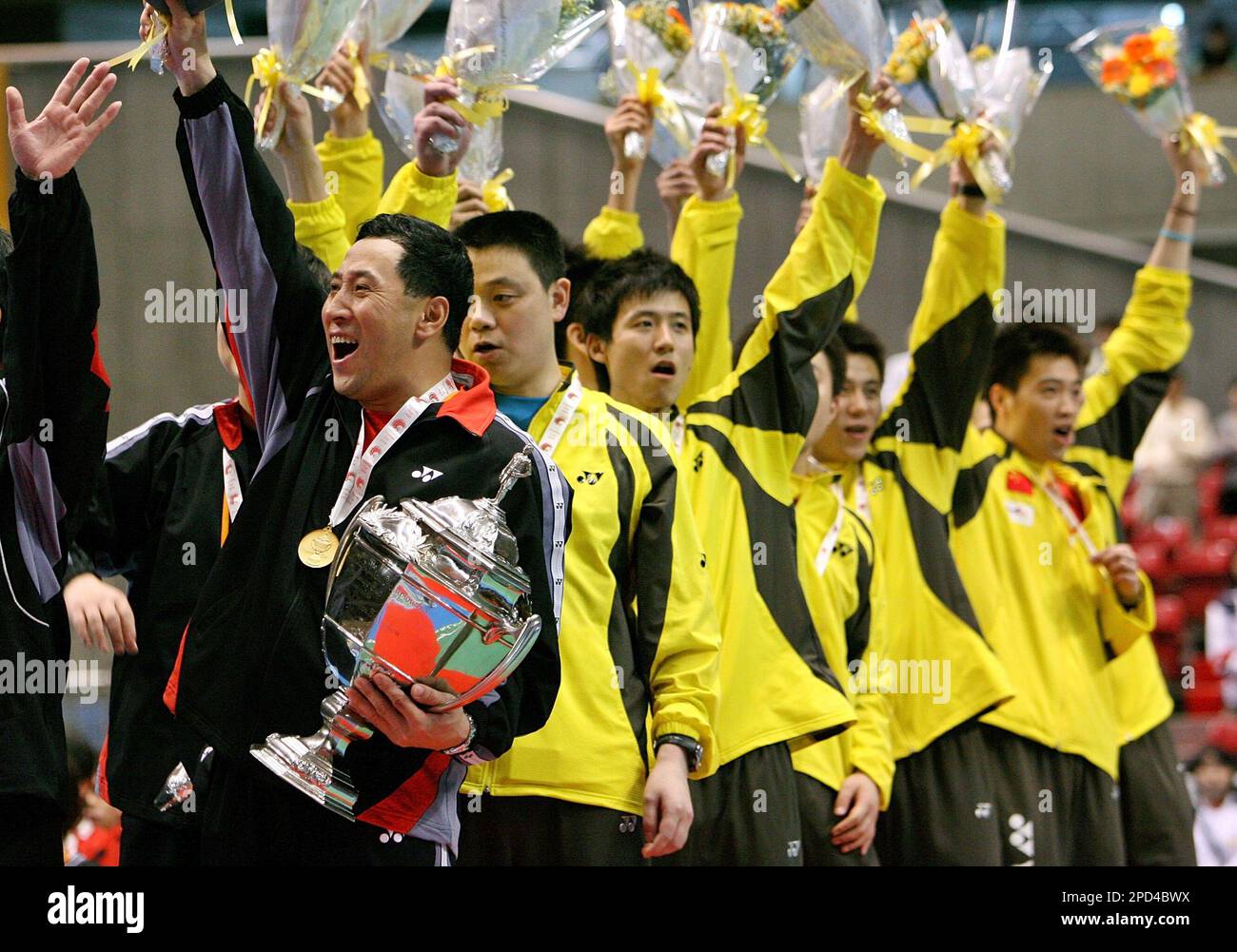 Chinas head coach Li Yongba, left, holds the Thomas Cup trophy as the team members acknowledge the crowd at the Thomas and Uber Cup Badminton final in Tokyo, Sunday, May 7, 2006.