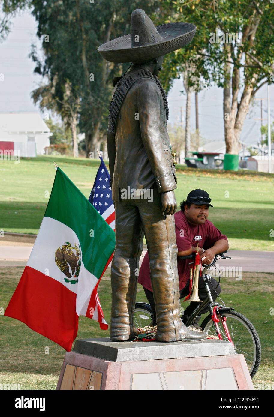 eduardo-reyes-stands-behind-a-statue-of-mexican-gen-emiliano-zapata-as