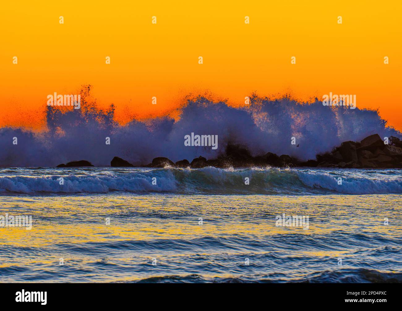 The beauty of a sunset landscape, with the ocean waves crashing against ...