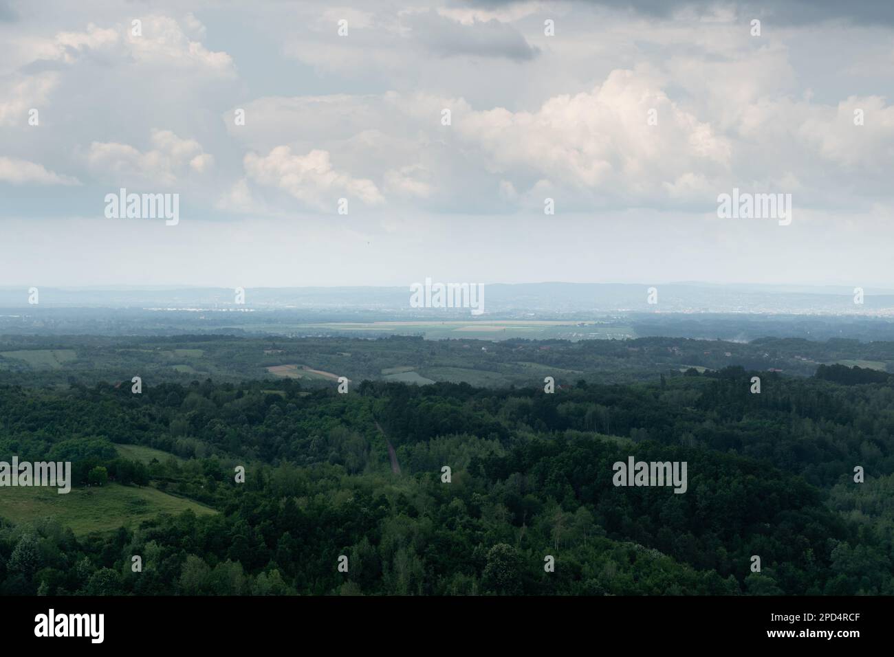 Hilly landscape with forests and stattered village during gloomy day ...