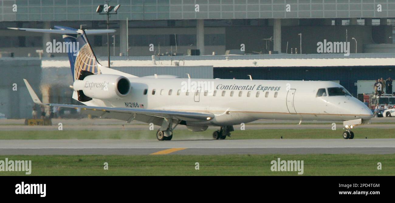 Smoke trails from the left landing gear of a Continental Express jet