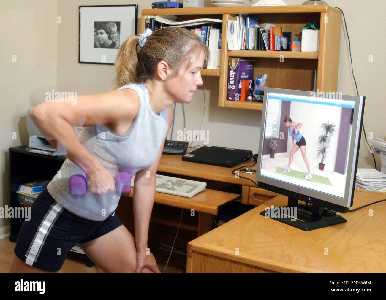 Michele Galindo exercises with a streaming video from a website while in  her Austin, Texas home on Wednesday, April 26, 2006. Now there are  alternatives to the gym and to exercise videos