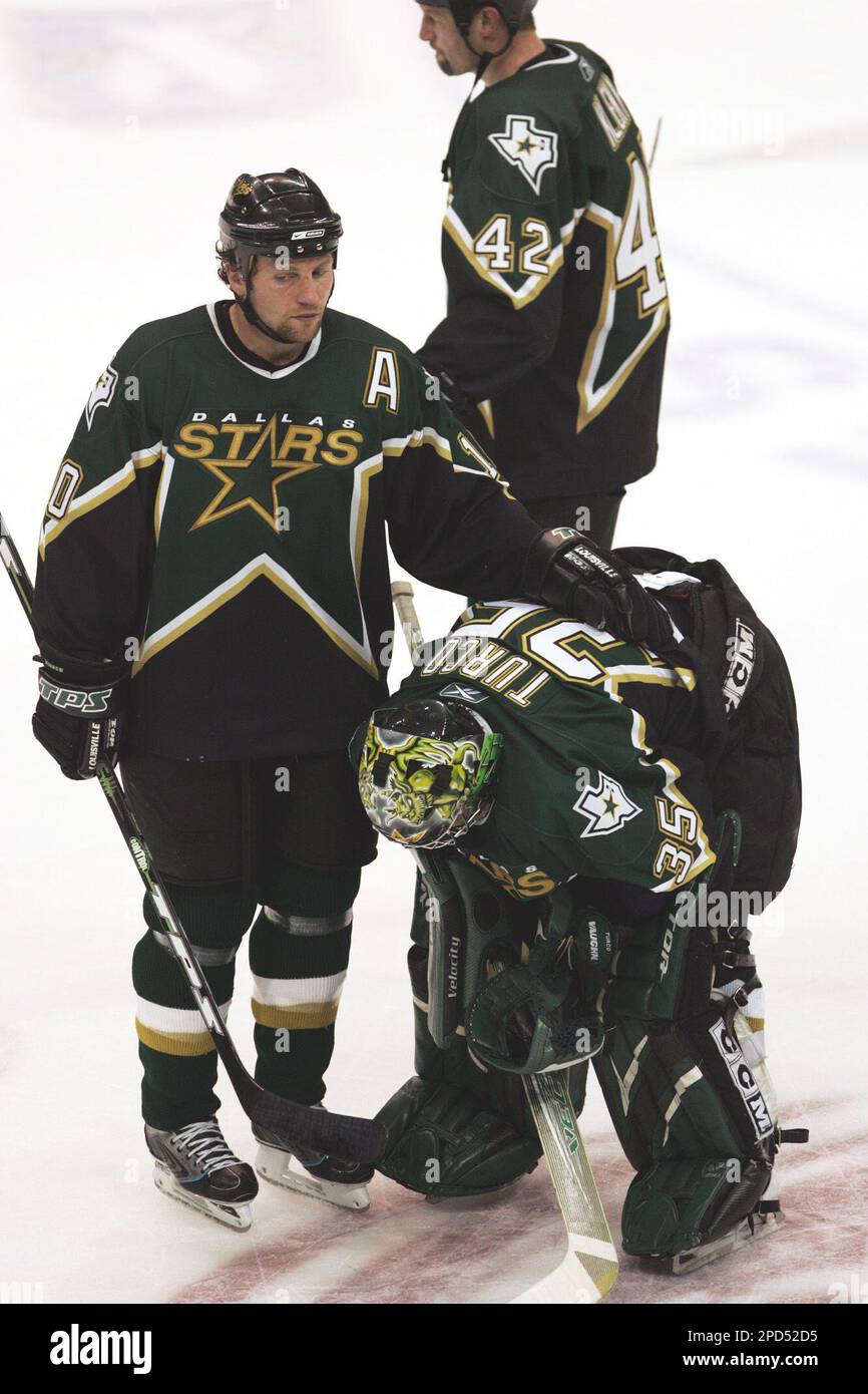 Dallas Stars goalie Marty Turco (35) is consoled by teammate left wing  Brenden Morrow, left, after their 3-2 loss to the Colorado Avalanche in  Game 5 of the teams' NHL hockey Western