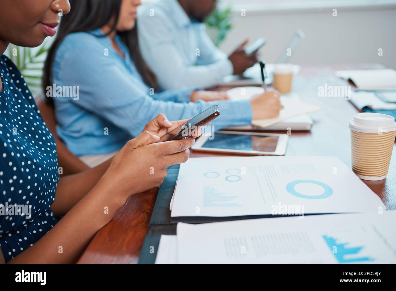 Texting Office Close up of Black woman texting during boardroom meeting, corporate ...