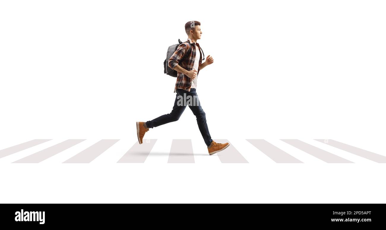 Full length profile shot of a male student running over pedestrian crossing isolated on white background Stock Photo