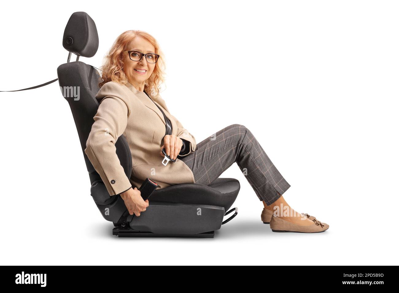 Mature woman sitting in a car seat and putting on a seatbelt isolated