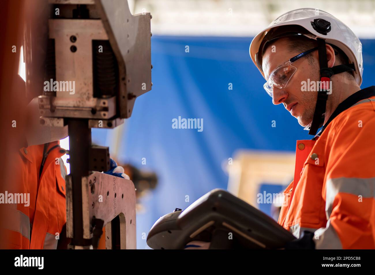 A team of male engineers meeting to inspect computer-controlled steel ...
