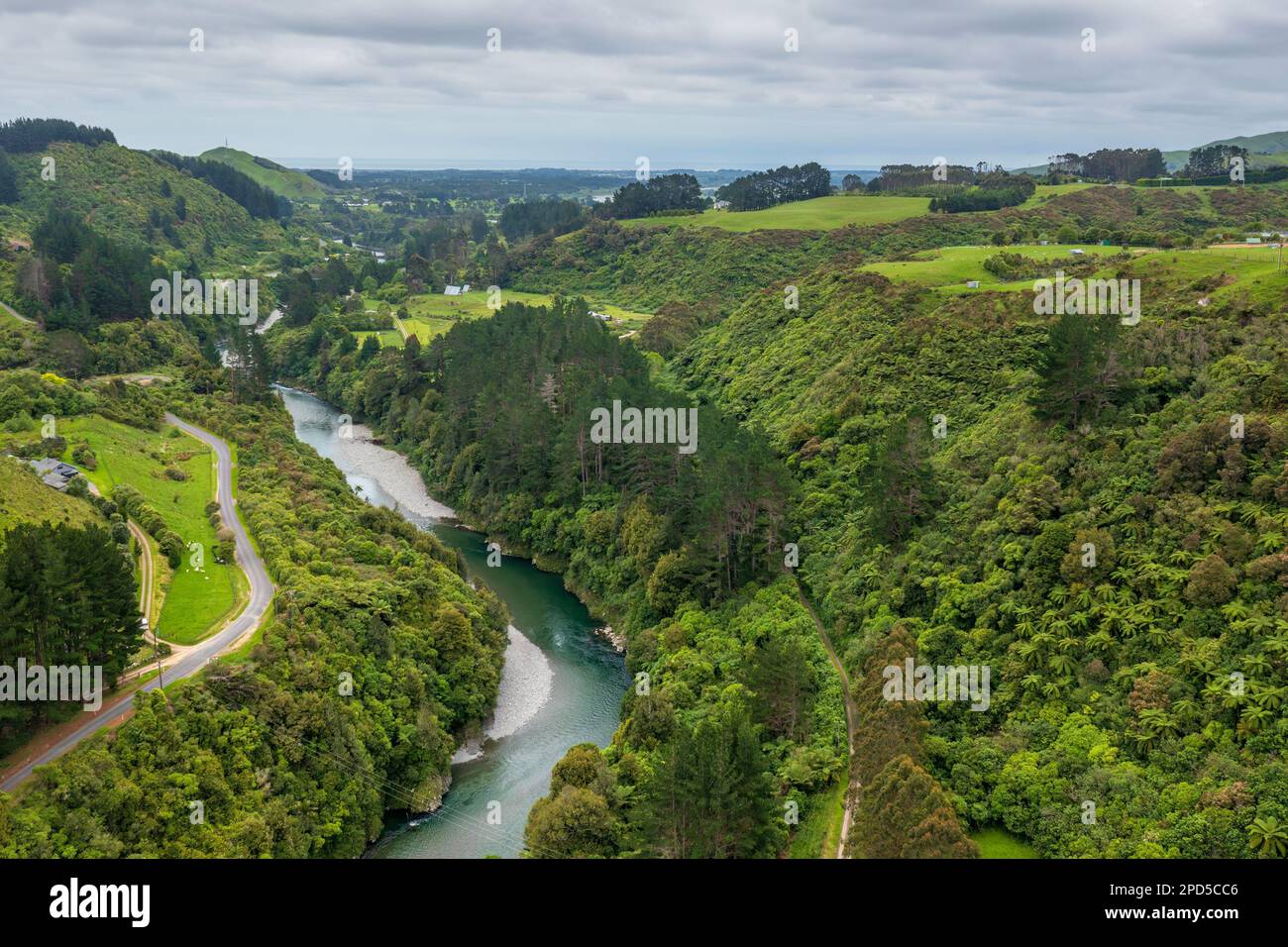 Aerial view of a scenic river winding through lush greenery and hills ...