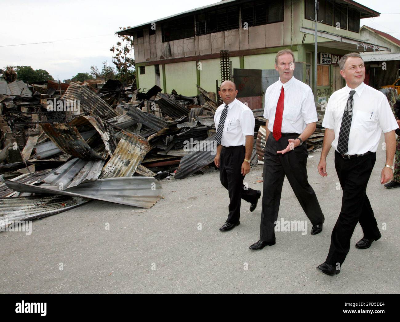 New Zealand Defense Minister Phil Goff, right, High Commissioner Brian  Sanders, center, and lawmaker Ron Mark take a first hand look at the damage  caused during the April 18 rioting and looting