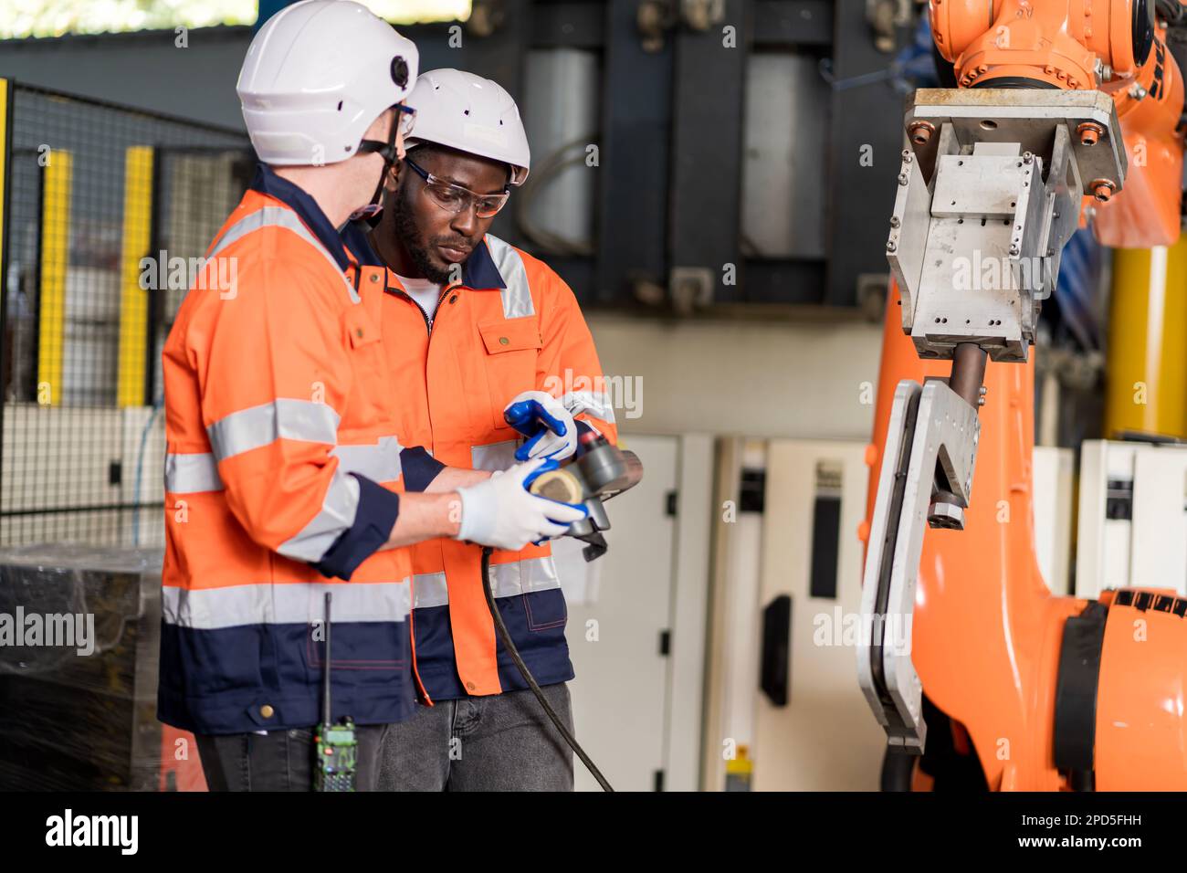 A team of male engineers meeting to inspect computer-controlled steel ...
