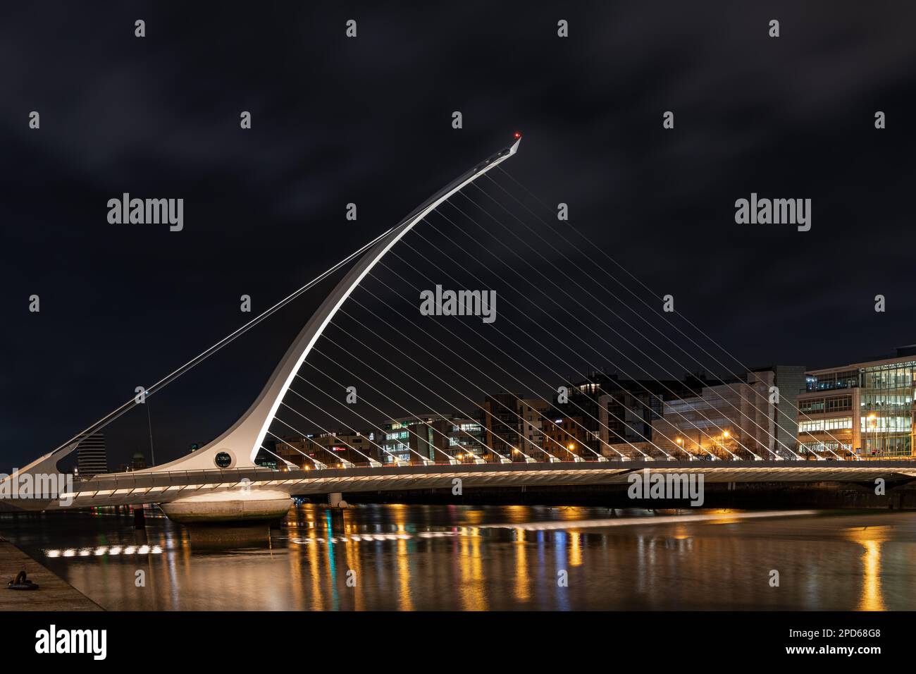 The Samuel Beckett Bridge over the River Liffey illuminated at night ...