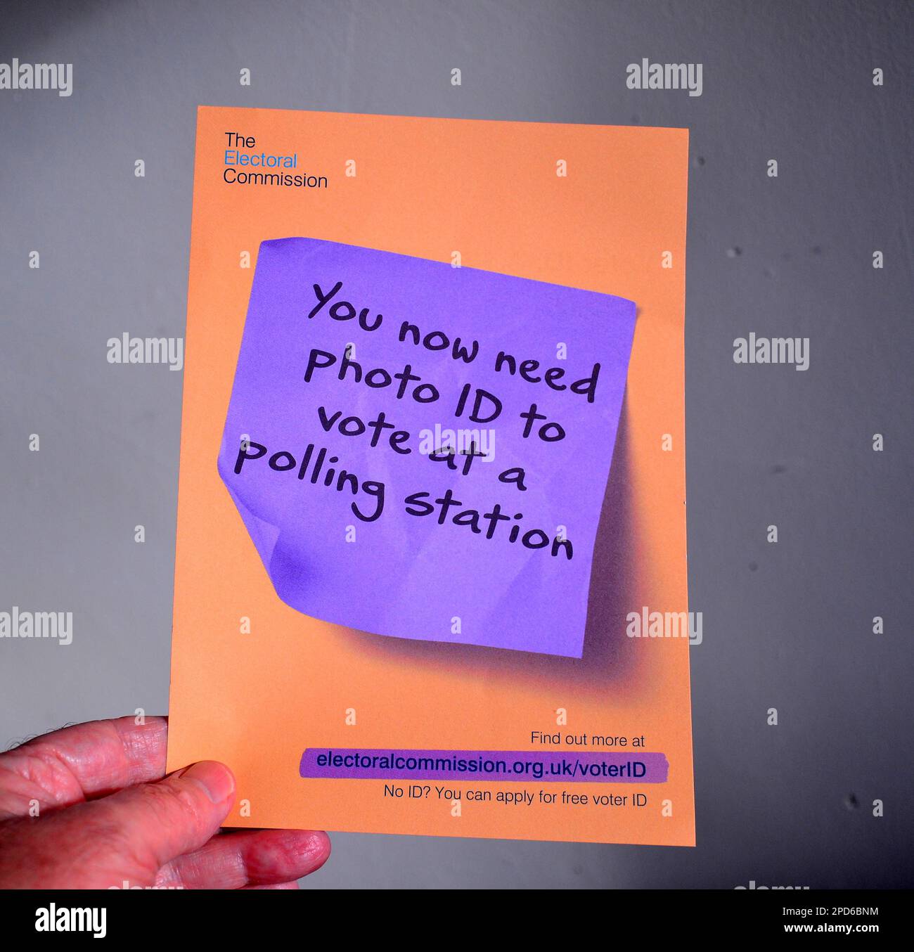 A man's hand holds an Electoral Commission leaflet informing people that voters in England will need to show voter ID in future. People in England will need to show photo ID in order to vote in person at the local elections on 4th May, 2023. The government intends this measure to help stop voter fraud. People who oppose the new measure think it will make it harder for some people to vote. Voters will have to show a photo ID to get their ballot paper in polling stations at local elections, police and crime commissioner elections, and parliamentary by-elections. Stock Photo