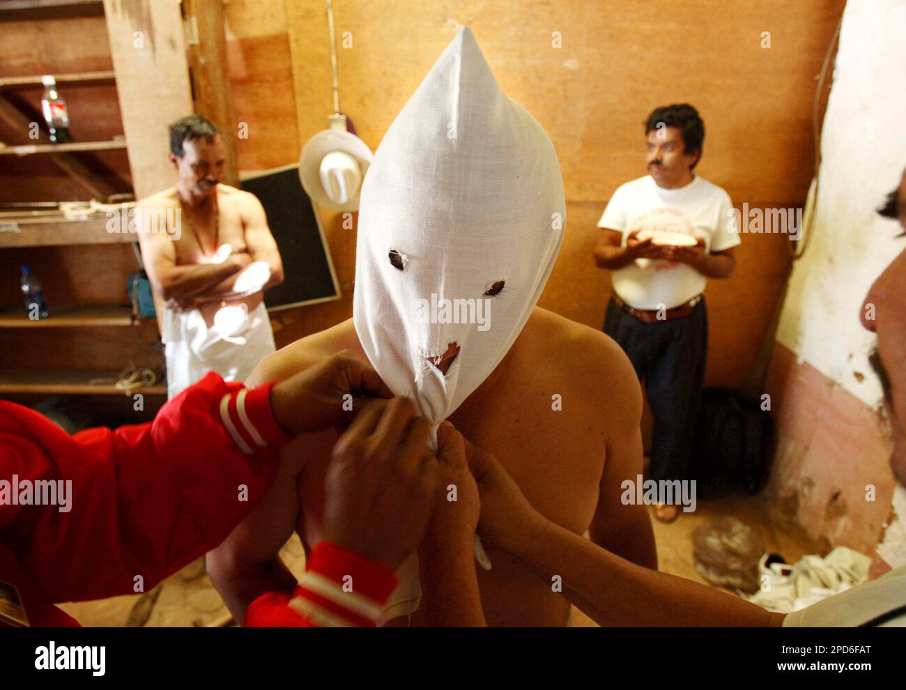 A man's head is covered with a hood pulled tight while shakled with  colonial Spanish shakles before starting his penitentiary rounds for Good  Friday in the town of Tzintzuntzan, Mexico, Friday, April