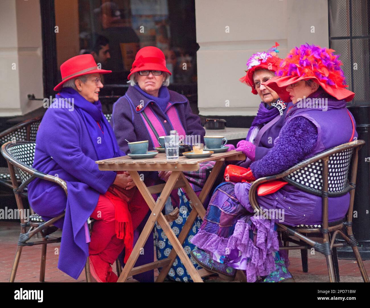 Ladies in purple on a Brighton street, England Stock Photo