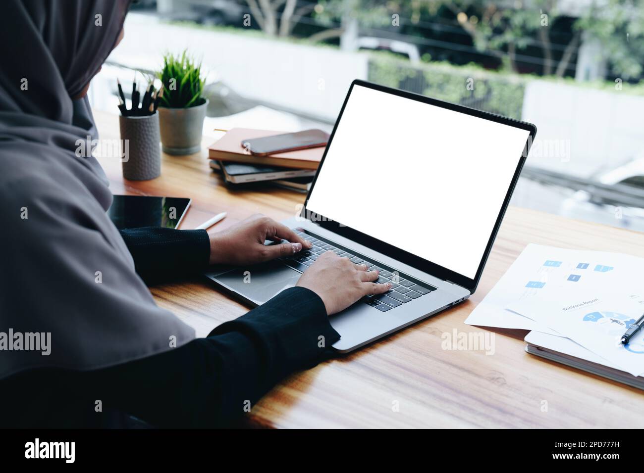 A beautiful Muslim woman uses a white computer screen ready to put text ...