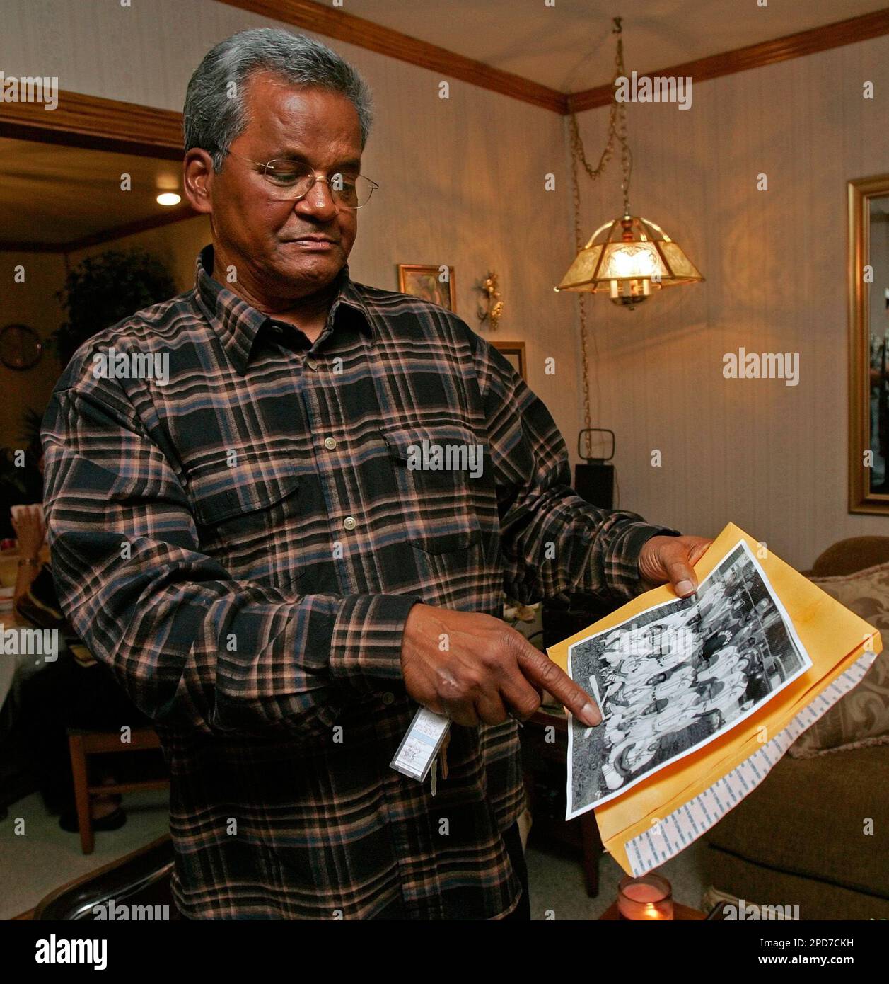 Frank Garnett points to a photograph of his youth baseball team during a  party with friends in Edgard, La., March 16, 2006. Garnett, know to his  buddies as "California Frankie," had grown