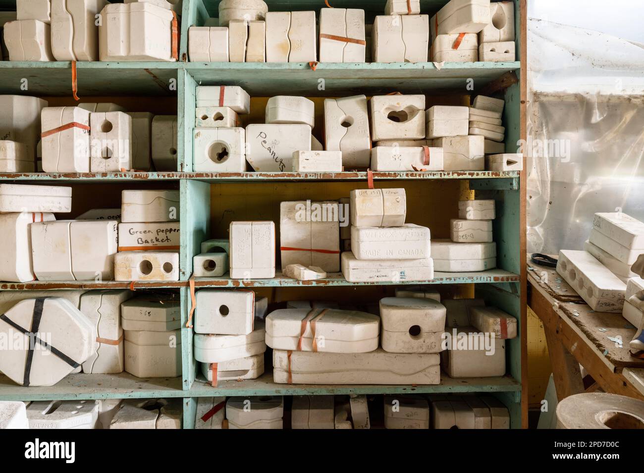 Dozens of ceramic molds sitting on shelves. Stock Photo