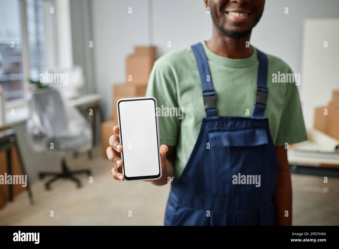 Worker Using Smartphone African American worker in uniform showing the screen of his smartphone ...