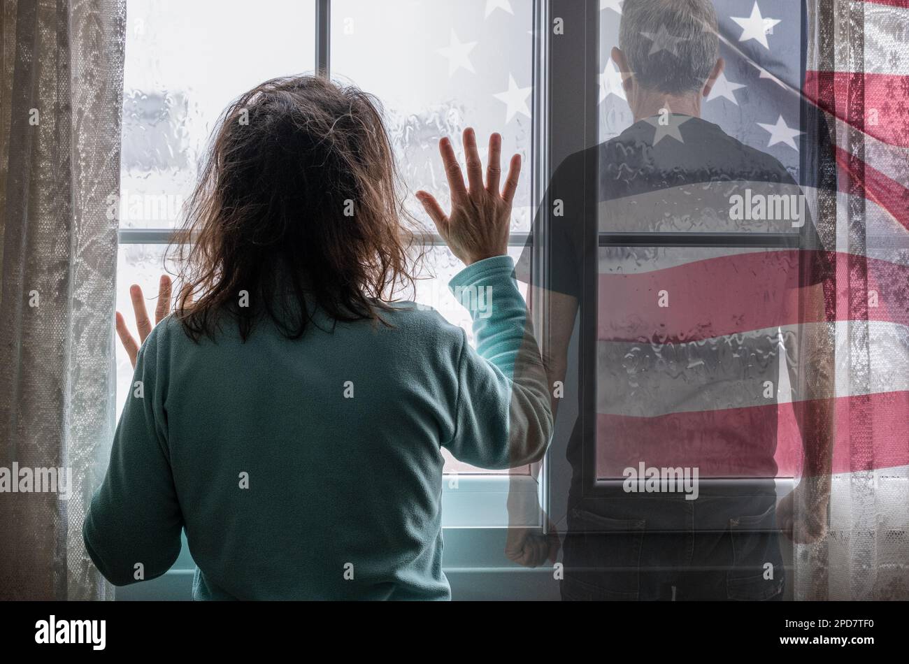 Woman looking out of window on rainy day. Man with clenched fists. Domestic abuse, violence, violent partner, trafficking, slavery, mental health... Stock Photo