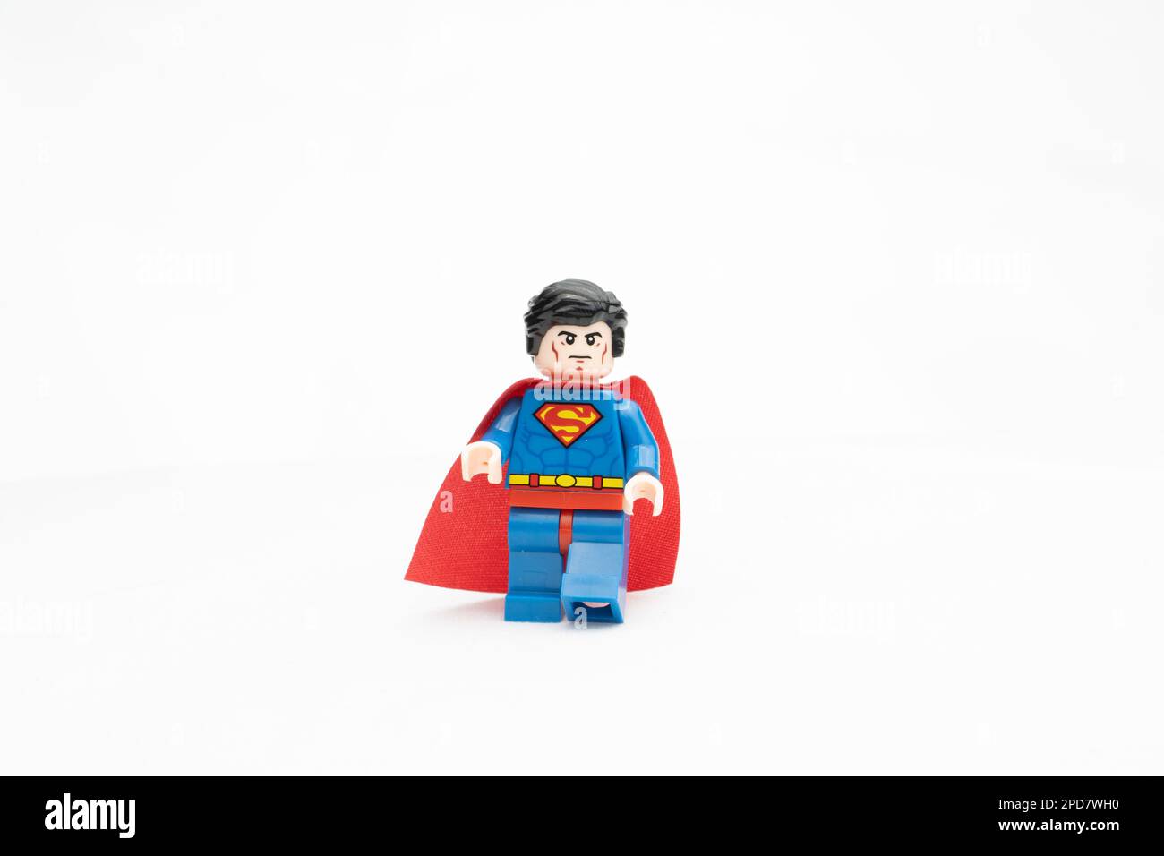 A Lego superhero figurine of Superman standing atop a white background Stock Photo