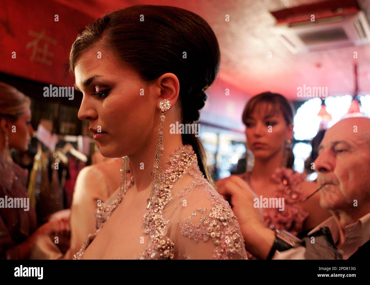 A Lebanese hairdresser fixes the hair of a model wearing a creation by Lebanese designer Hanna