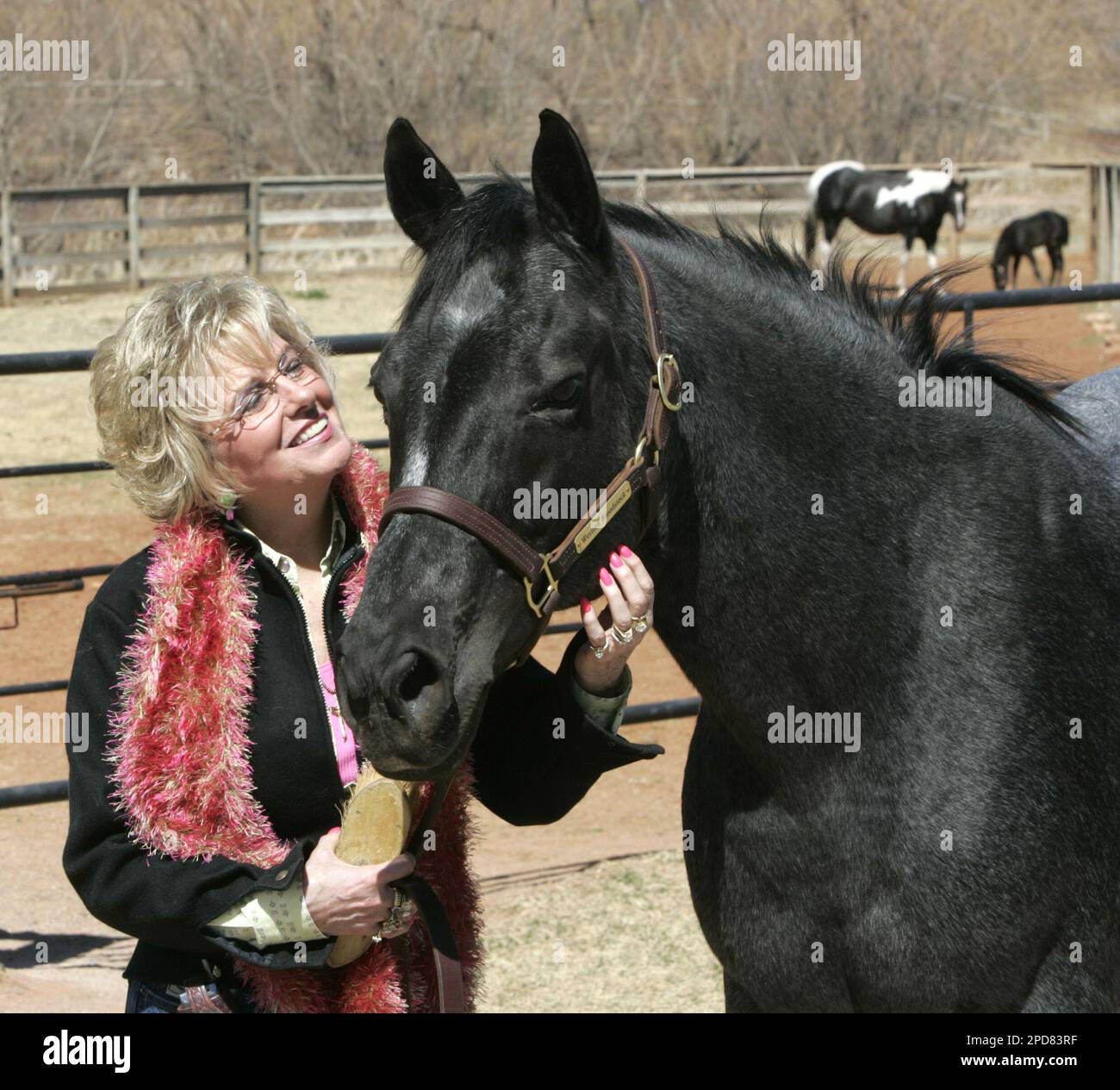 Elaine Hall poses for a photo with her prize cutting horse, Royal Blue