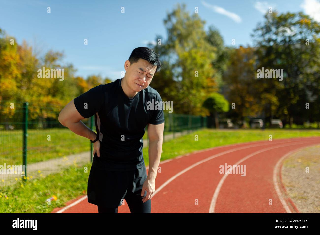 Asian sportsman has severe pain in back and abdominal muscles, man peed