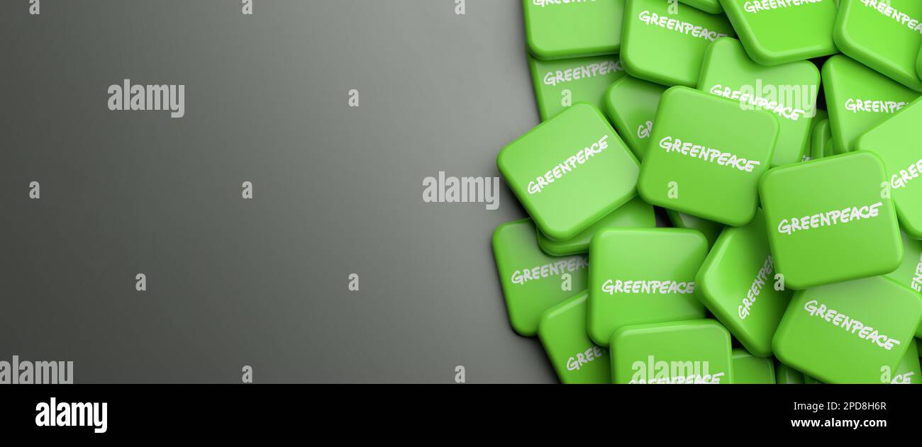 Logos of the environmental organization Greenpeace on a heap on a table. Copy space. Web banner format. Stock Photo