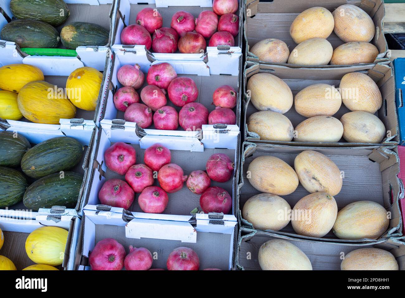 Various varieties of melons and pomegranates in a box for sale in the ...