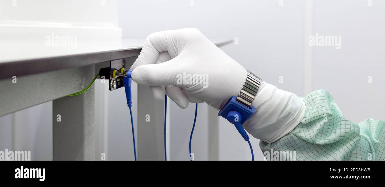 Ground bracelet on man hand wearing ESD cloth for clean room. Antistatic ESD wrist strap or ground bracelet is an antistatic device used to safely gro Stock Photo