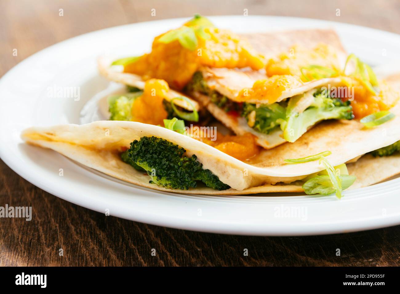 Plate with vegan broccoli quesadillas, served with an apricot-carrot sauce. Stock Photo