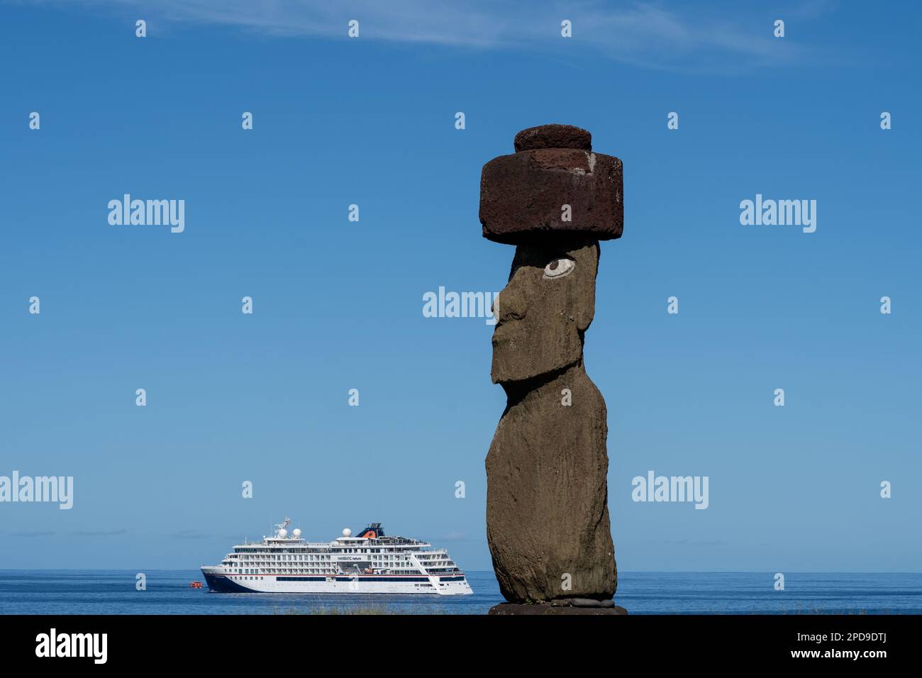 Easter Island, Chile - March 6, 2023: The moai with headgear and eyes on Ahu Ko Te Riku with a cruise ship in the background on Easter Island Stock Photo