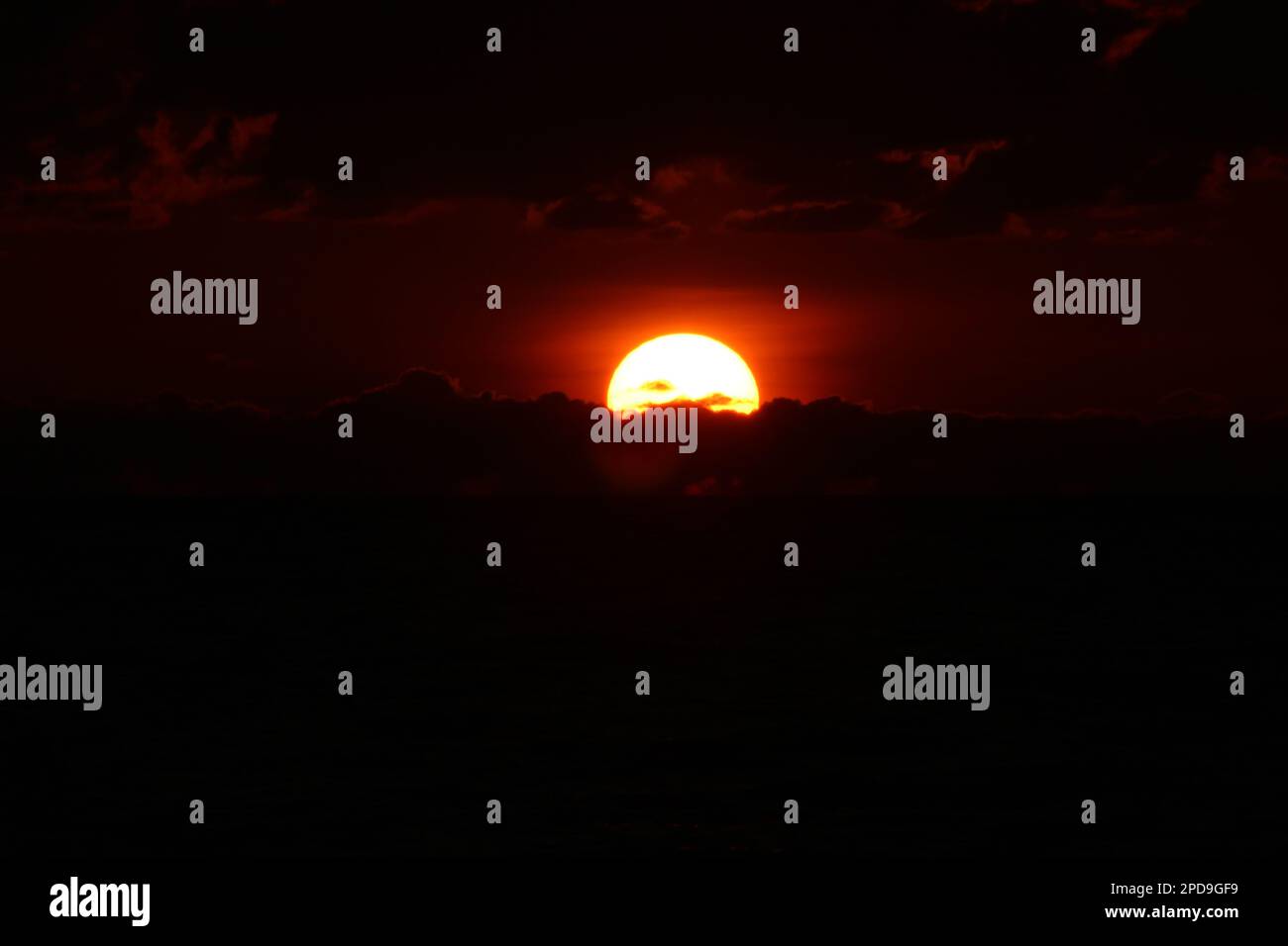 The sun setting over the landscape with clouds Stock Photo