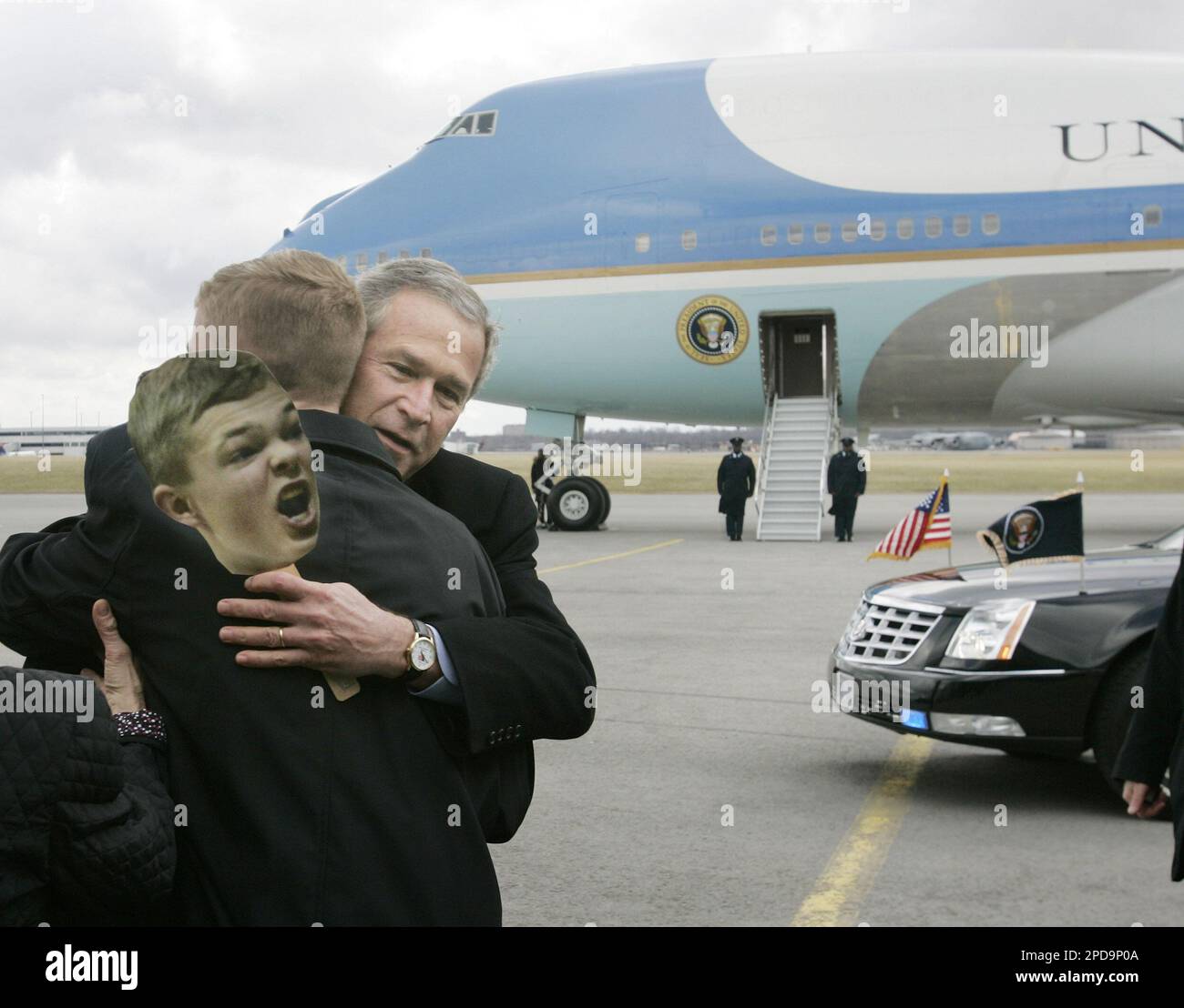 President Bush hugs autistic high school senior Jason McElwain of Rochester, N.Y., whose image is also seen on the cutout, after stepping off Air Force One, rear, at Greater Rochester International Airport
