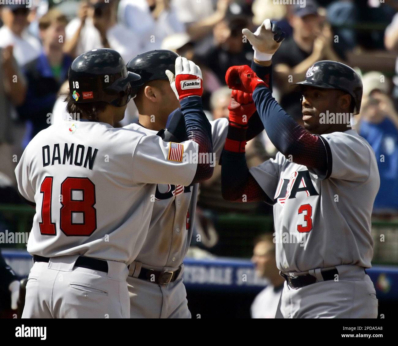 Team USA's Derek Jeter (rt) congratulates teammate Ken Griffey, Jr. as  Griffey crosses homeplate on a homerun in the second inning against Team  South Africa in the World Baseball Classic game in