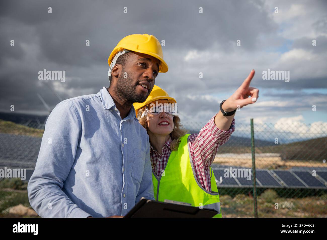 Two colleagues at a solar power plant work, international renewable energy industry Stock Photo
