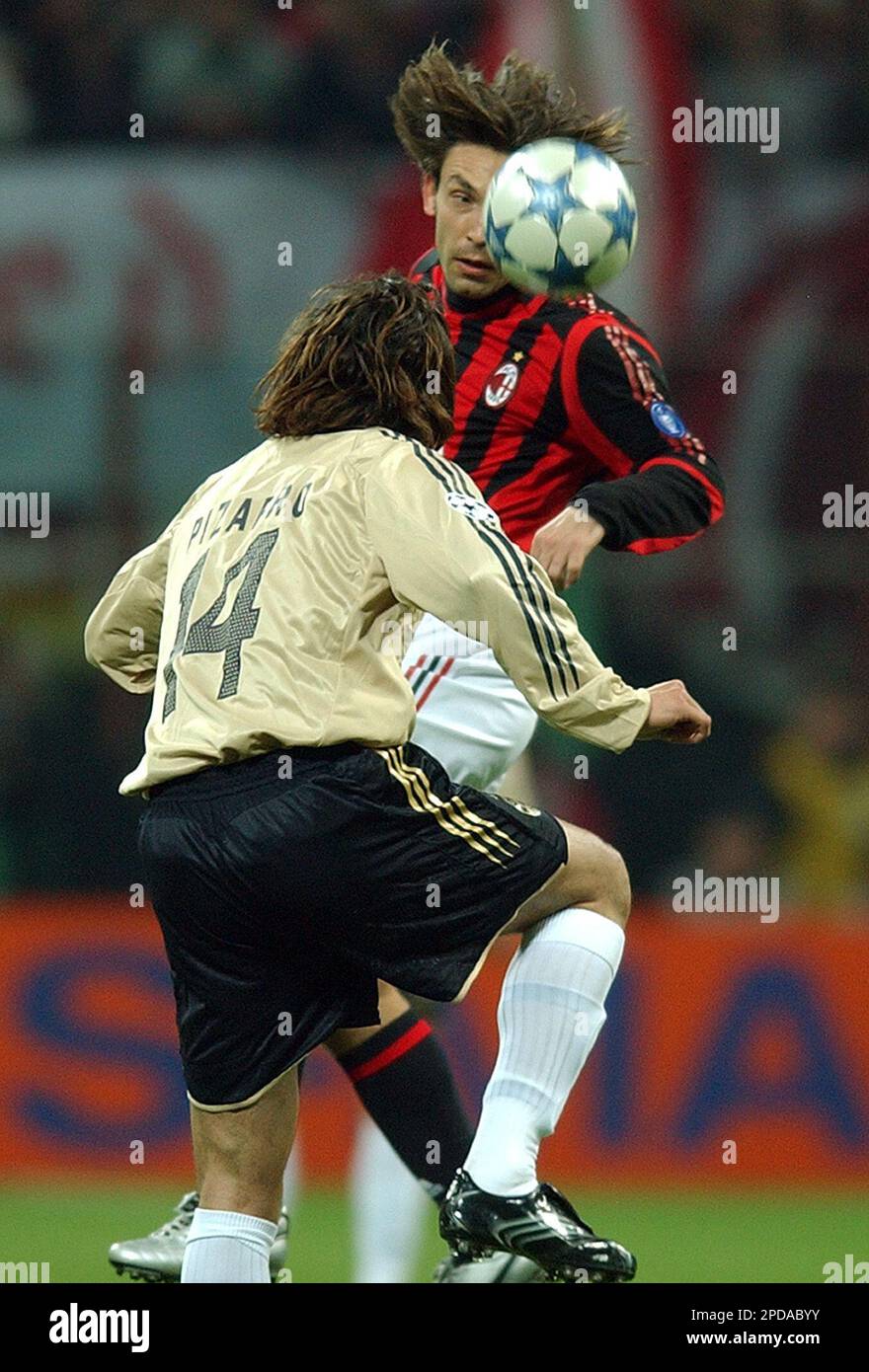 AC Milan's Andrea Pirlo, face to camera, jumps for the ball with Bayern  Claudio Pizarro, of Peru, during a Champions League first knockout round  2nd leg soccer match between AC Milan and