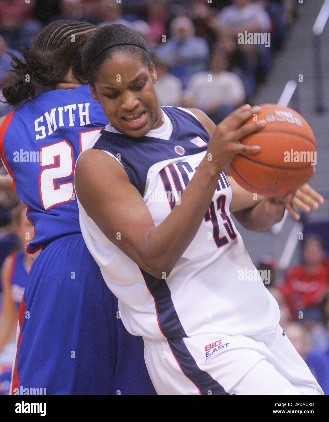 Connecticut s Willnett Crockett pulls in a rebound over DePaul s