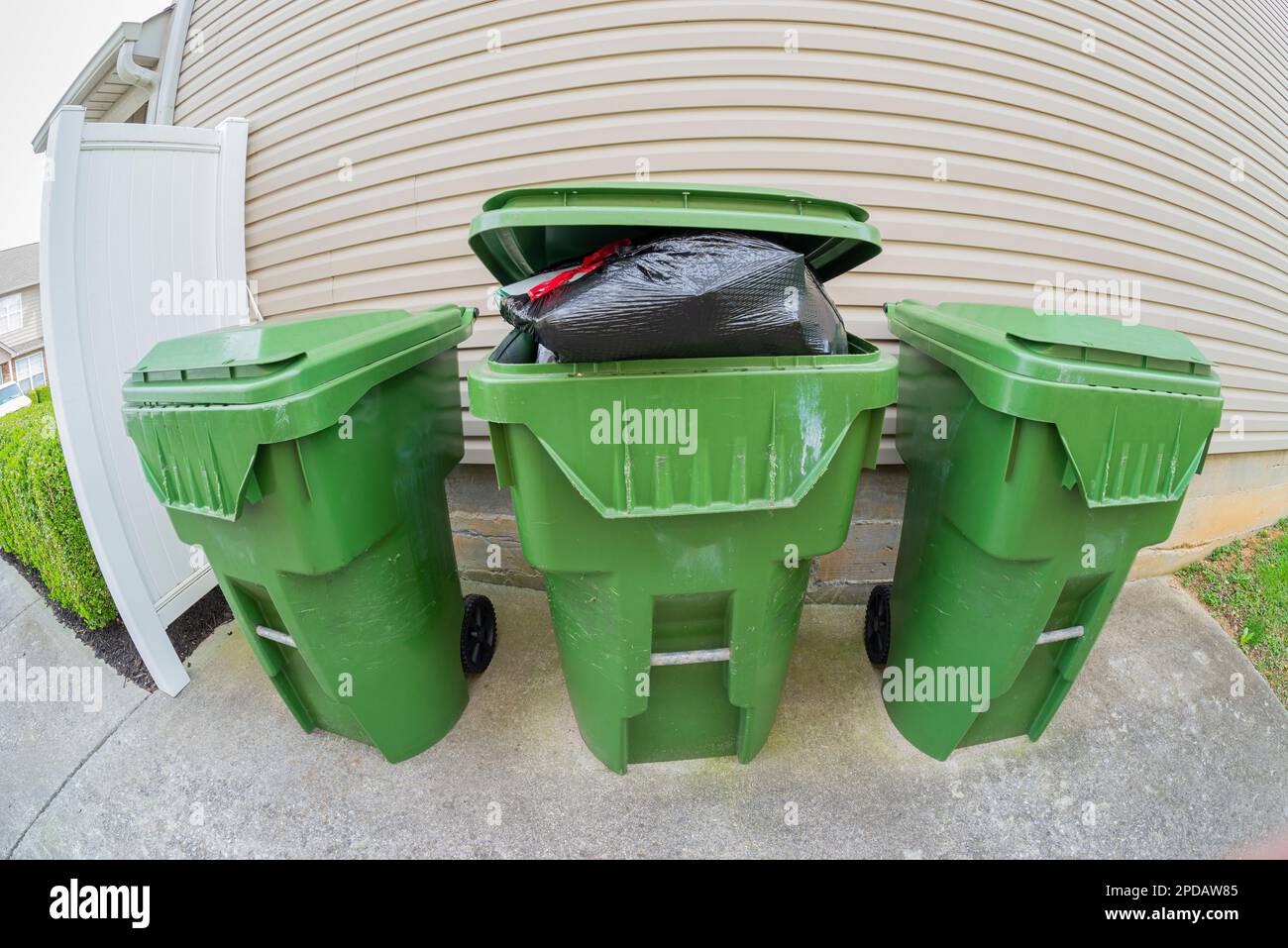 Horizontal fisheye lens view of an overstuffed trash bin. Stock Photo