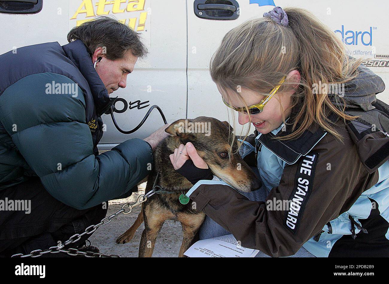 Bend Ore., musher Rachael Scdoris, right, holds one of her sled dogs as