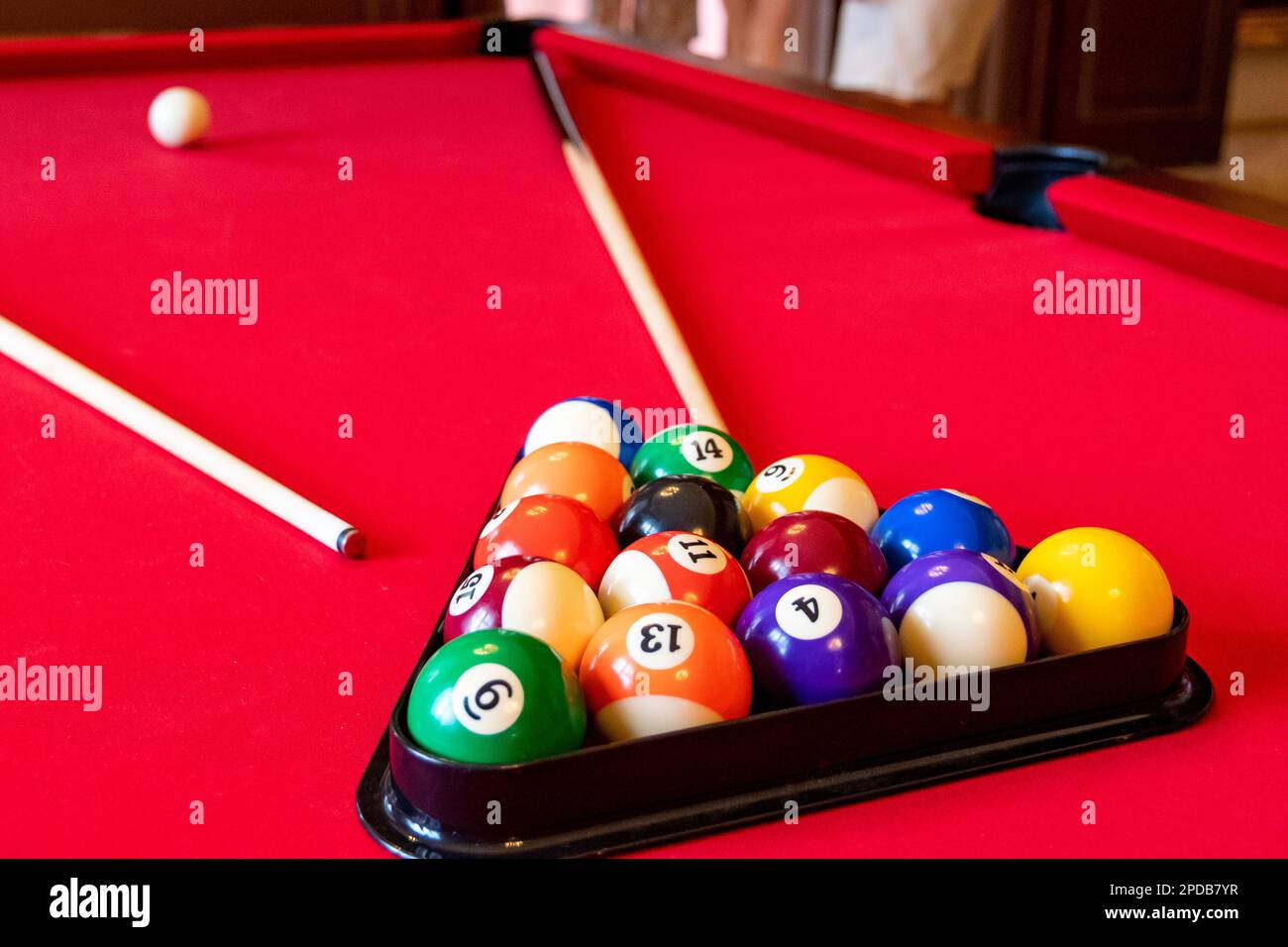 Red billiard table with billiard balls and cues Stock Photo