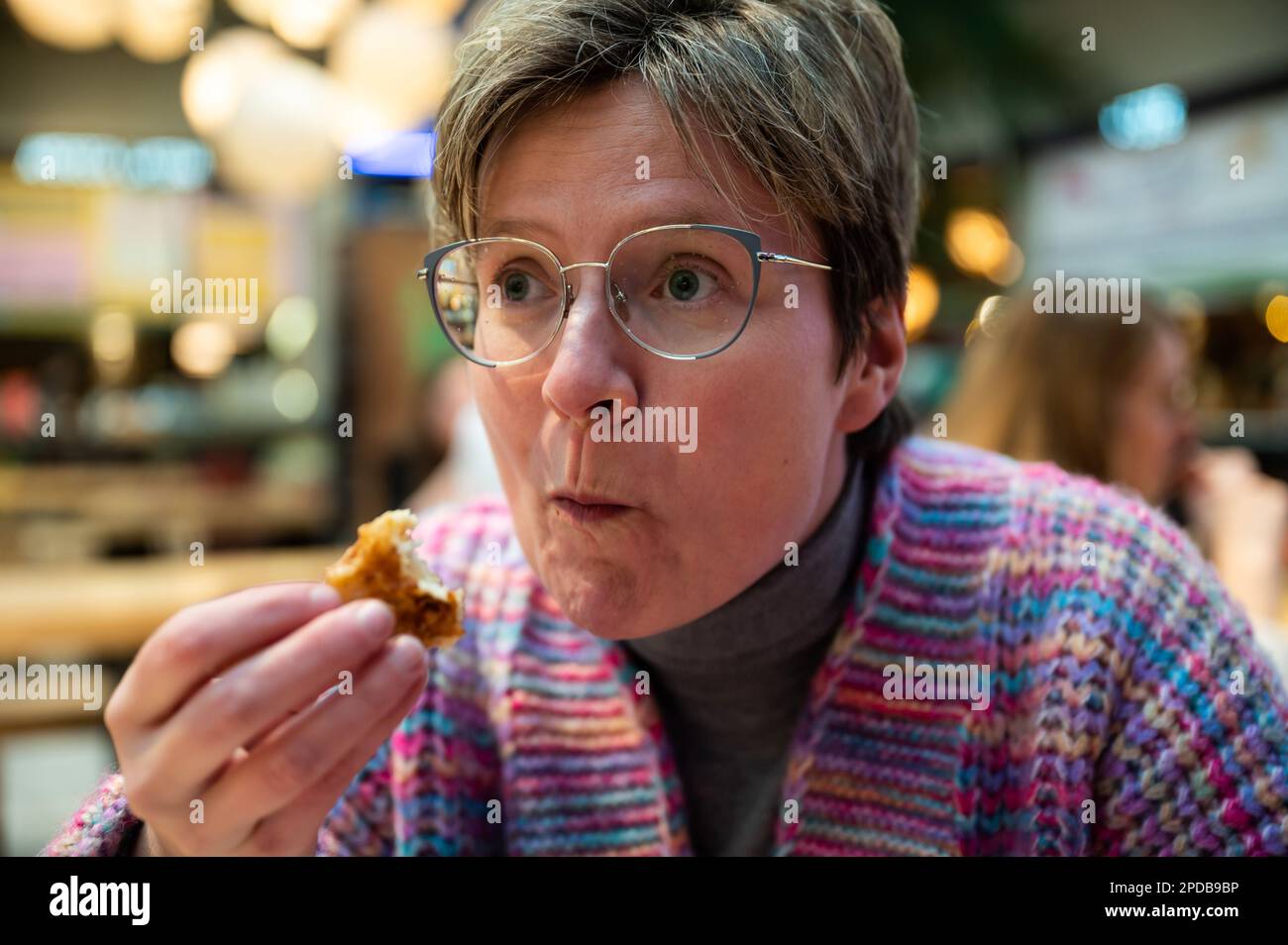 36 year old white woman eating indoors, Brussels, Belgium Stock Photo