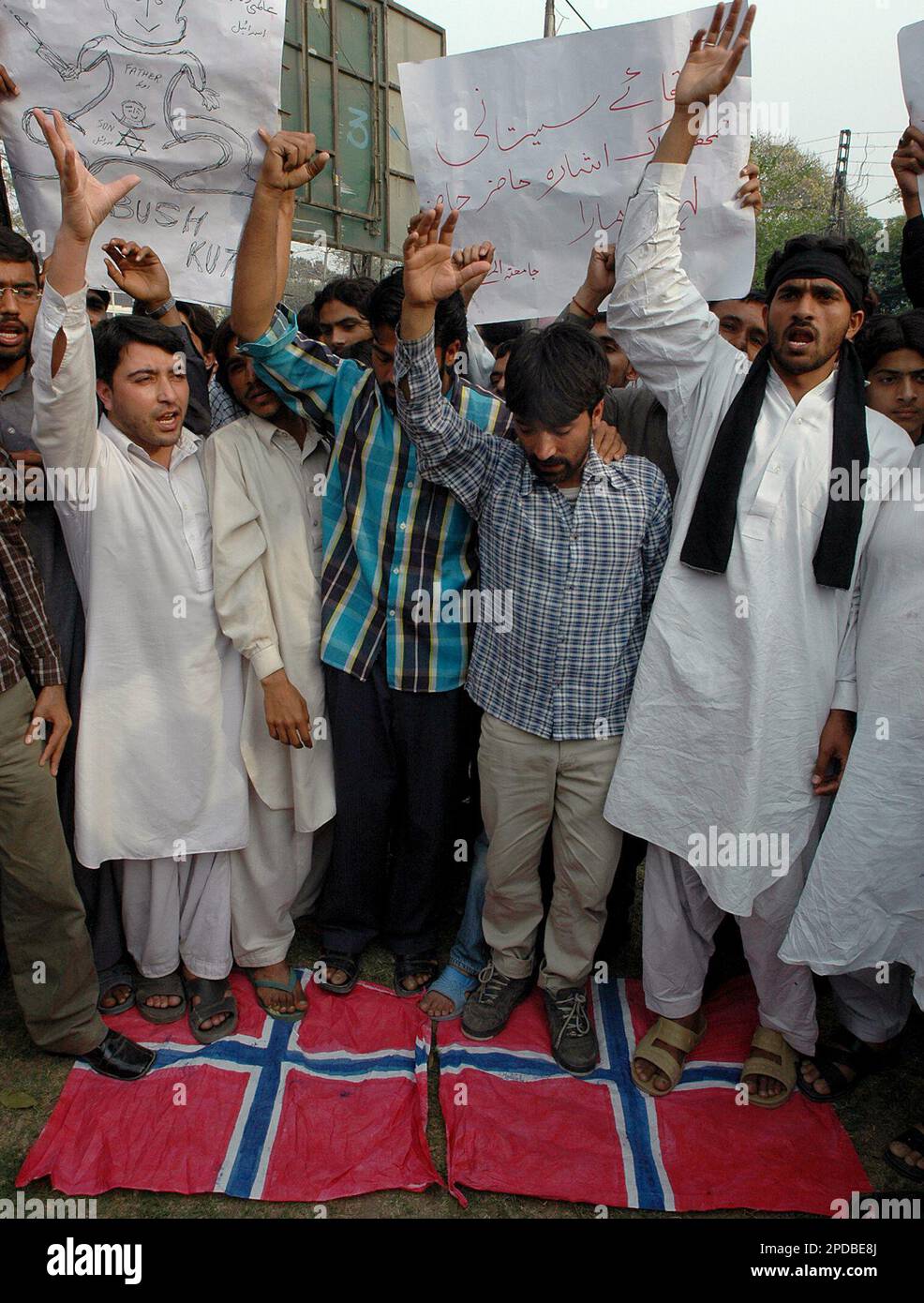 Pakistani protesters stand on the Danish flags and chant slogans during ...